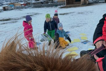 Children during a winter activity with a horse in the snow; a child holds the reins in the foreground. | © Katharina Gläser
