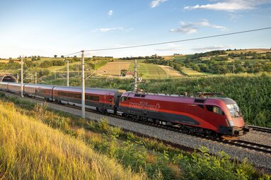 ÖBB Railjet travelling on an electrified railway line between fields and vineyards. | © ÖBB, Foto Harald Eisenberger