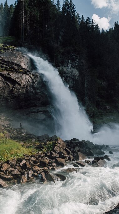 Die Krimmler Wasserfälle stürzen über Felsen in einen Gebirgsbach. Wald und felsige Hänge umgeben den Wasserfall. | © SalzburgerLand Tourismus, Foto Christoph Perkles