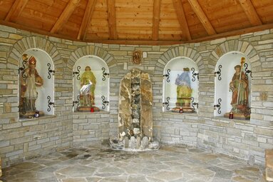 Naglköpfl Chapel with stone walls and 4 saint statues in niches under a wooden roof. | © TVB Piesendorf Niedernsill, Foto Harry Liebmann