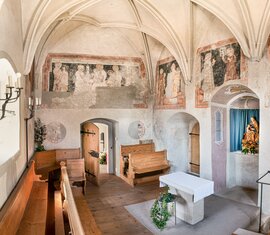 Innenraum der Michaelskapelle in Piesendorf mit historischen Wandmalereien, Kreuzrippengewölbe, Holzbänken und Altar. | © TVB Piesendorf Niedernsill, Foto Harry Liebmann