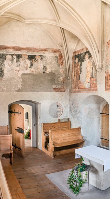 Interior of St. Michael's Chapel in Piesendorf with historic wall paintings, ribbed vault, wooden pews and altar. | © TVB Piesendorf Niedernsill, Foto Harry Liebmann