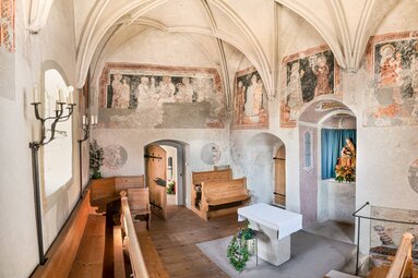 Innenraum der Michaelskapelle in Piesendorf mit historischen Wandmalereien, Kreuzrippengewölbe, Holzbänken und Altar. | © TVB Piesendorf Niedernsill, Foto Harry Liebmann