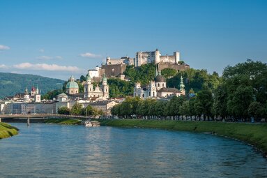 View across the Salzach to Salzburg's Old Town with church towers and Hohensalzburg Fortress on the hill above. | © Salzburg Tourismus