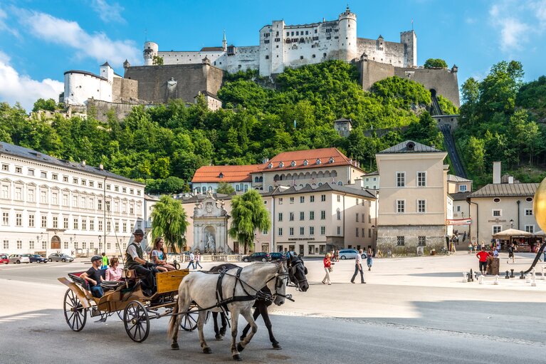 Kapitelplatz in Salzburg mit Pferdekutsche und goldener Kugel, dahinter die Festung Hohensalzburg. | © Tourismus Salzburg GmbH