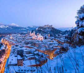 Snow-covered Salzburg at dusk with the Salzach river, illuminated old town and Hohensalzburg Fortress. | © Tourismus Salzburg, Foto: Breitegger Günter