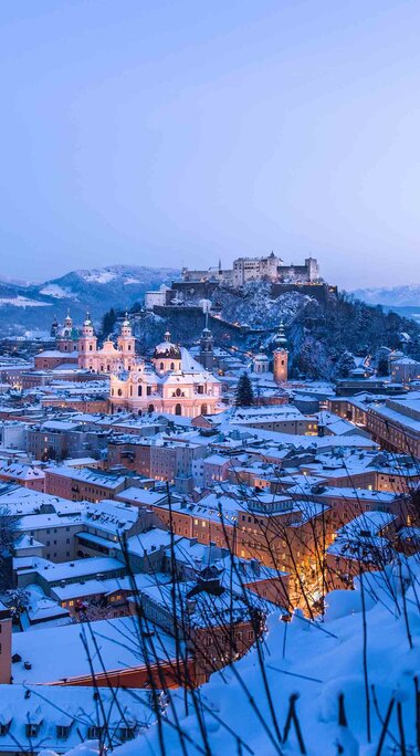 Snow-covered Salzburg at dusk with the Salzach river, illuminated old town and Hohensalzburg Fortress. | © Tourismus Salzburg, Foto: Breitegger Günter