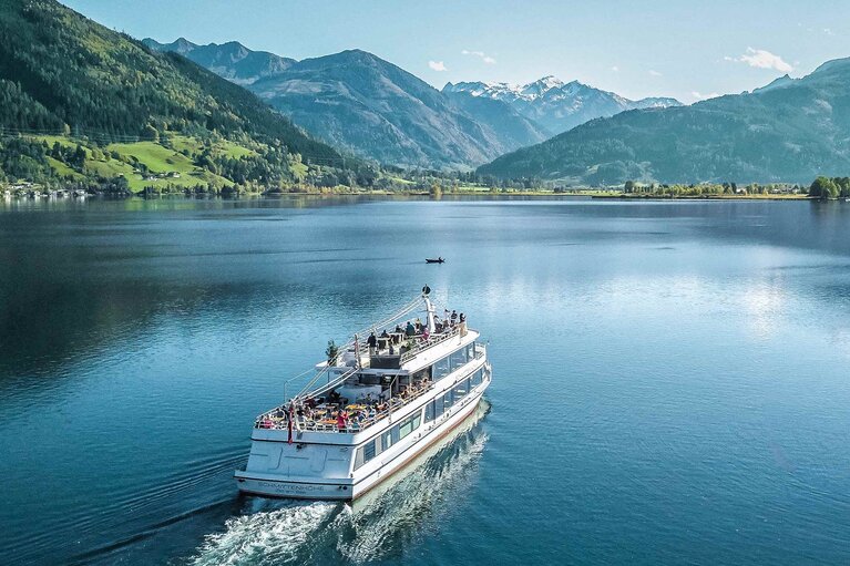 Ausflugsschiff auf dem Zeller See vor bewaldeten Berghängen und Berggipfeln. | © Schmittenhöhebahn AG