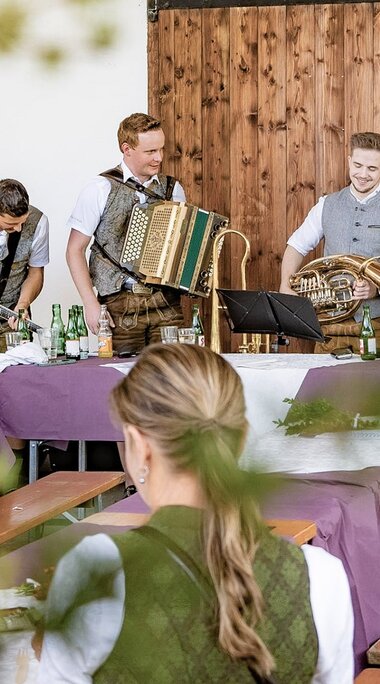 Musikgruppe in Tracht mit Kontrabass, Gitarre, Ziehharmonika und Blasinstrumenten beim Bartlmä Fest. | © Lichtfarben