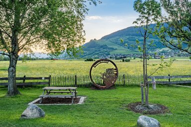 Isonta photo point with a bench by a meadow, overlooking Piesendorf-Niedernsill and the surrounding mountain slopes. | © TVB Piesendorf Niedernsill, Foto Lichtfarben
