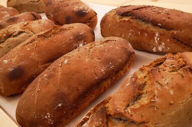 Several loaves of farmhouse bread with browned crusts, some topped with seeds. | © Guads vo Dahoam