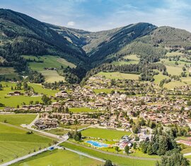 Aerial view of Piesendorf with the village centre, meadows and forested mountain slopes in the background. | © TVB Piesendorf Niedernsill, Foto Harry Liebmann 