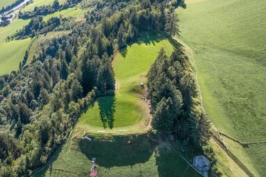 Luftaufnahme des Verteidigungswalls am Naglköpfl mit Wiesen, Wald, Wegen und Sitzbänken. | © TVB Piesendorf Niedernsill, Foto Harry Liebmann
