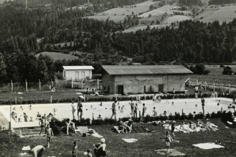 Historische Aufnahme des ersten Schwimmbads in Piesendorf mit Badegästen im Becken und auf der Liegewiese. | © TVB Piesendorf Niedernsill