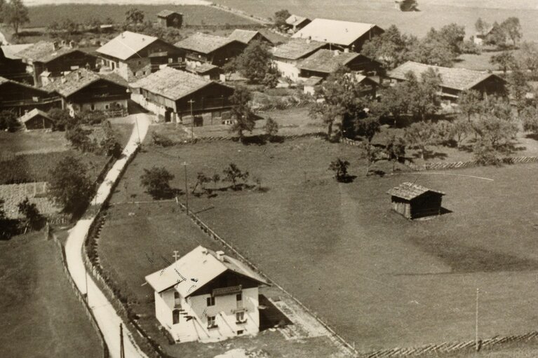 Historische Ansicht von Friedensbach um 1954 mit Bauernhäusern, Straße, Wiesen und Feldern. | © TVB Piesendorf Niedernsill