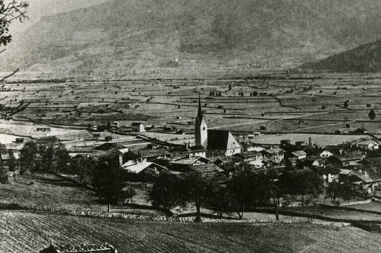 Historische Ansicht von Piesendorf vor dem Ersten Weltkrieg mit Kirche, Häusern und landwirtschaftlichen Flächen. | © TVB Piesendorf Niedernsill