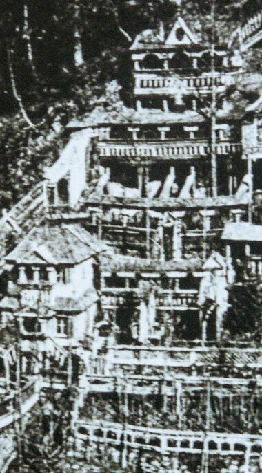 Historische Aufnahme von 1879 mit mehrgeschossigen Holzbauten, Türmen, Balkonen und Terrassen an einem bewaldeten Hang. | © TVB Piesendorf Niedernsill