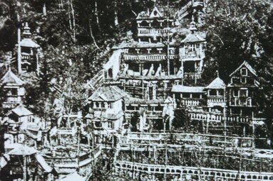 Historische Aufnahme von 1879 mit mehrgeschossigen Holzbauten, Türmen, Balkonen und Terrassen an einem bewaldeten Hang. | © TVB Piesendorf Niedernsill