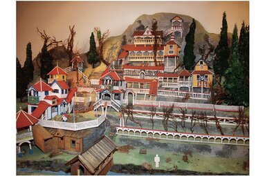 Modell der Chinesenstadt mit mehrstöckigen Gebäuden, Türmen, Veranden und Treppen an einem bewaldeten Berghang. | © TVB Piesendorf Niedernsill