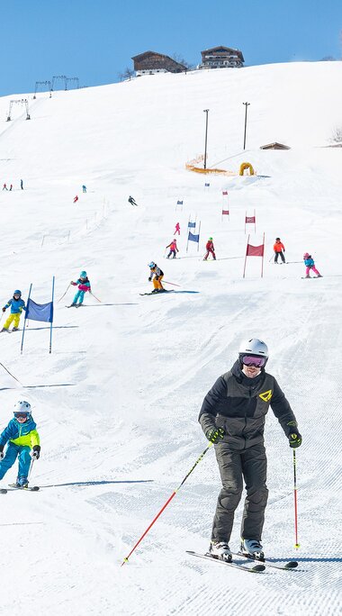 Skifahrende auf der Skipiste am Erlebnisberg Naglköpfl in Piesendorf, darunter eine erwachsene Person und ein Kind. | © TVB Piesendorf Niedernsill, Foto Harry Liebmann 