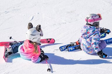 Two children sitting in the snow after a fall on the ski slope. | © Lichtfarben