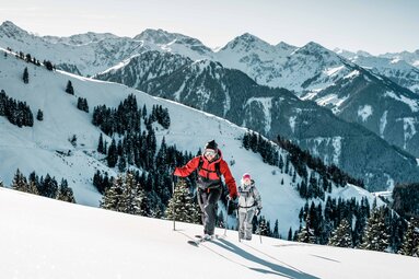 Two ski tourers ascending a snow-covered slope in the Kitzbühel Alps. | © Mediahouse, Max Draeger