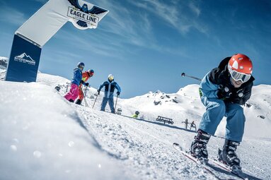 Child skis down the Eagle Line at Kitzsteinhorn while other skiers wait at the start. | © Kitzsteinhorn