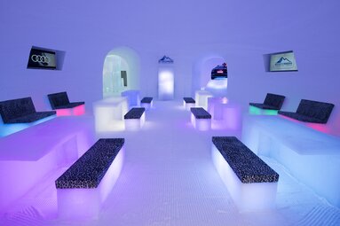 ICE Lounge at Kitzsteinhorn with ice benches and tables illuminated by colorful lights. | © Kitzsteinhorn