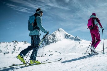 Zwei Personen steigen mit Tourenski und Stöcken durch die verschneite Berglandschaft am Kitzsteinhorn auf. | © Kitzsteinhorn