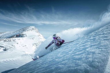 Skier descends a snow-covered slope at Kitzsteinhorn, spraying snow during a turn. | © Kitzsteinhorn