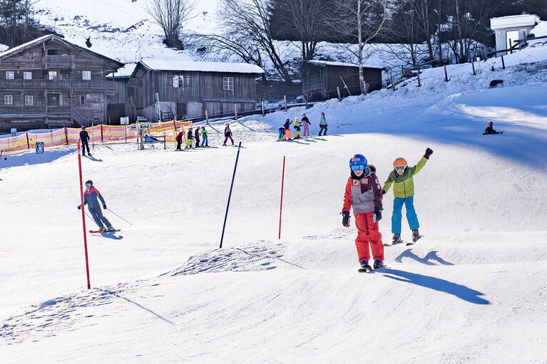 Kinder fahren auf einer präparierten Skipiste mit Wellen und Übungsbereich. | © Lichtfarben