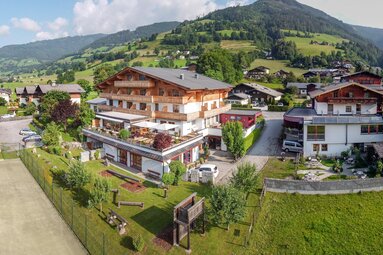 Notburgahof with balconies, terrace and garden, set against the green mountain slopes of Piesendorf-Niedernsill. | © Notburgahof