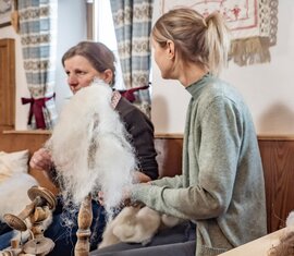 Two women process wool using traditional spinning tools at Dietlgut. | © Lichtfarben