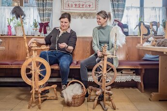 Two women spinning wool on traditional spinning wheels at Dietlgut. | © Lichtfarben