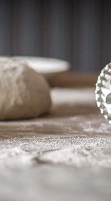 Bemehlte Brotteiglinge liegen neben einem Brotstempel auf einer Arbeitsfläche und sind zum weiteren Verarbeiten vorbereitet. | © Lichtfarben